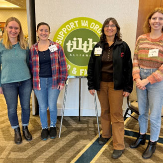 A group of women scientists standing together in a conference room.