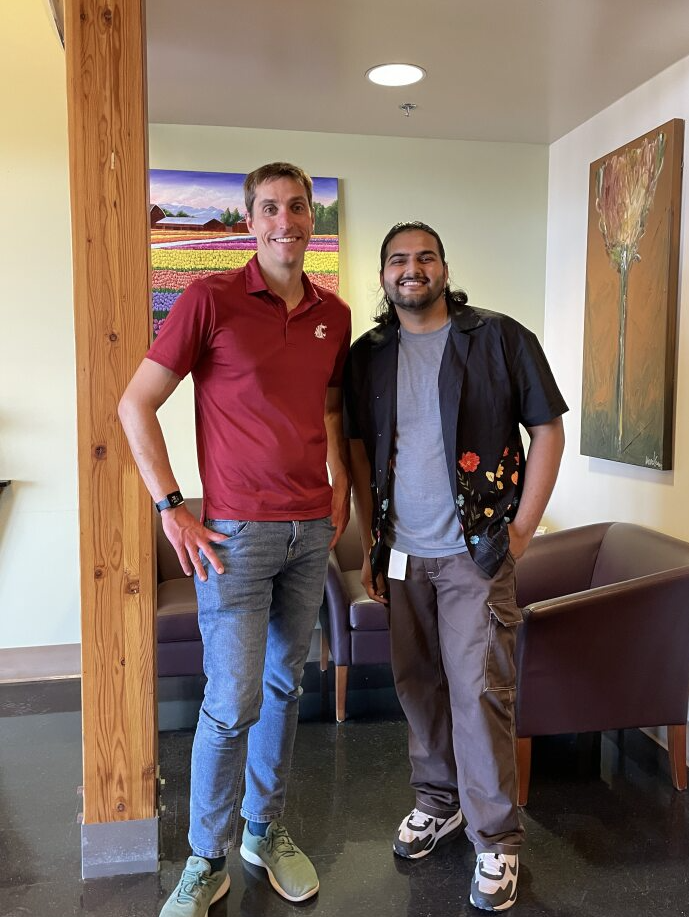 Two people standing in a building lobby, they are smiling.