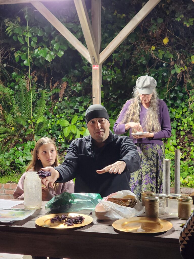 Frank Lake stand behind a table of indigenous food ingredients.