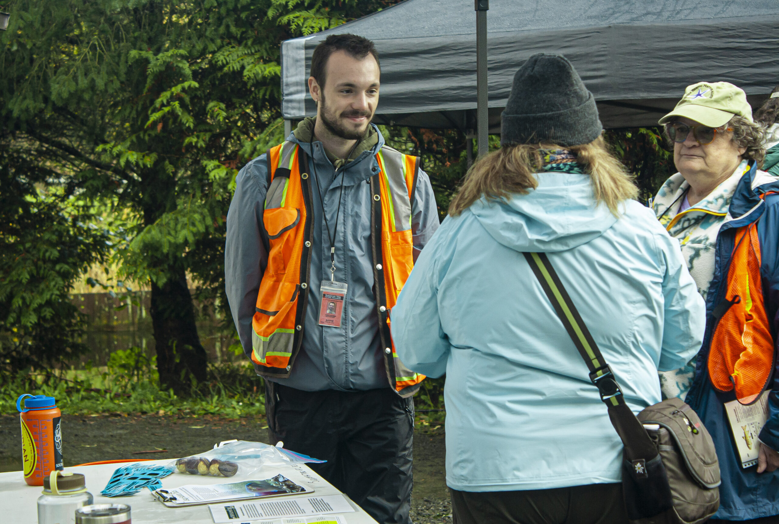 Photo of field biologist for the Suquamish Tribe and a salmon docent talking to the public about salmon at Salmon Tours event at Merle Hayes Salmon Enhancement Center.