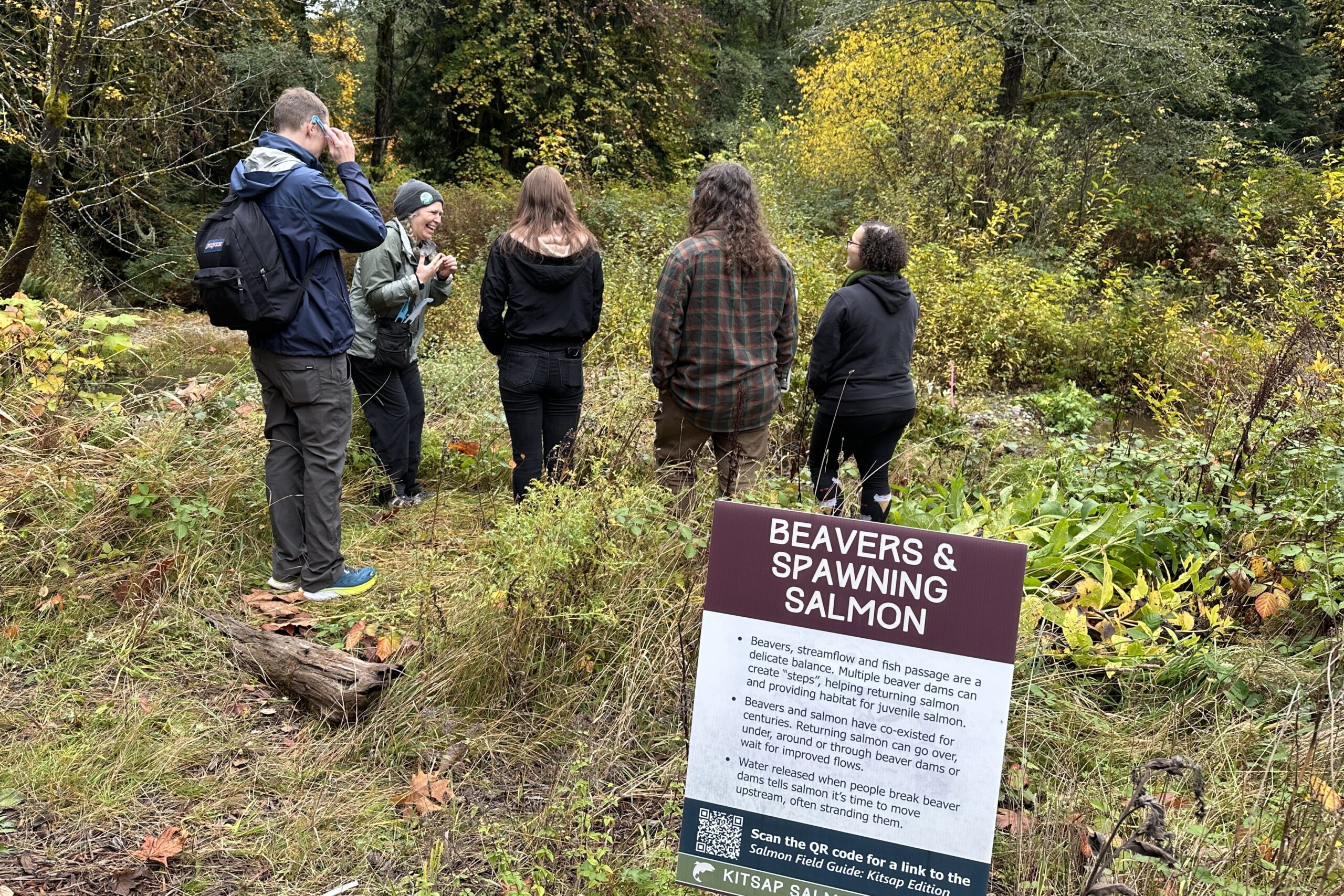 Photo of Salmon Docent talking with a small group of college students with their professor by Chico Creek at the Rhododendron Preserve for Salmon Tours event