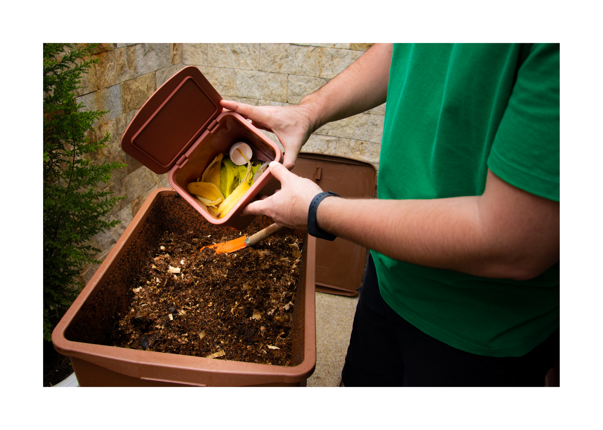 Person adding food scrap to inhome stealth composting unit which is a small scale, passive, method of composting. 