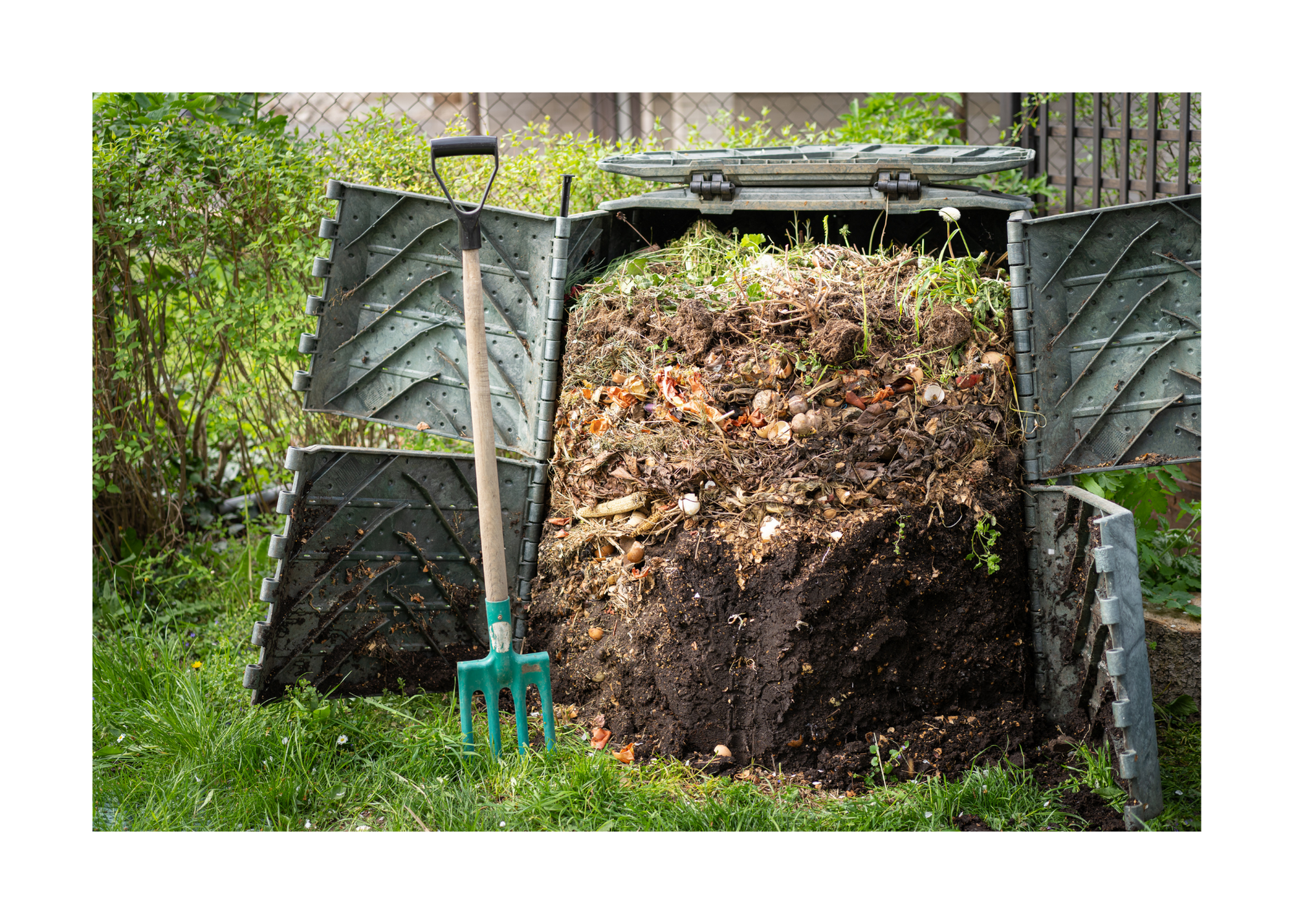 Upright plastic cylinder with side doors that are open exposing different layers to decomposing compost