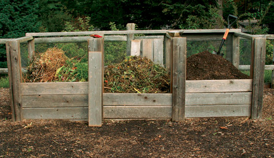three bins of composting material at different stages of decay for composting.