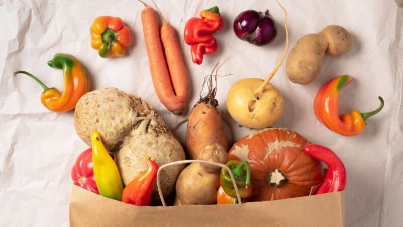 Decorative Image of Misshapen Produce Items coming out of grocery bag