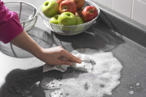 Person washing counter with sudsie water