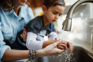 Image of mother and son wash hands with soap and water