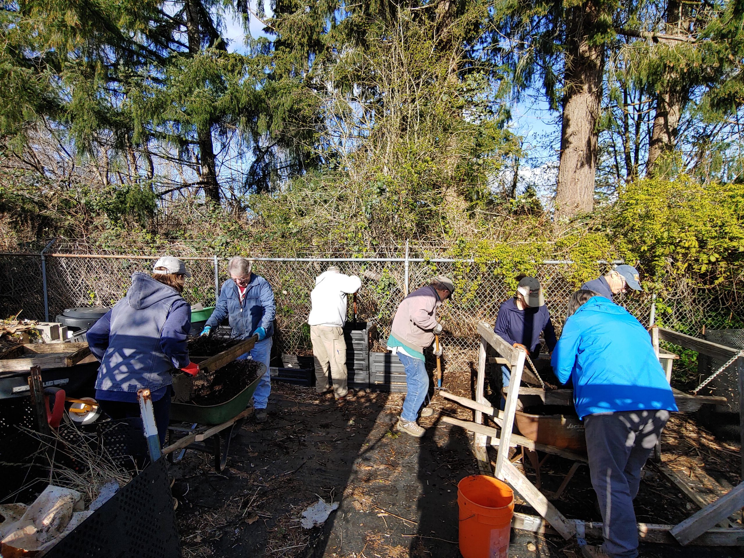 Master Recycler Composter volunteers building compost piles and sifting finished compost at Dirt Works Demonstration Garden. 
