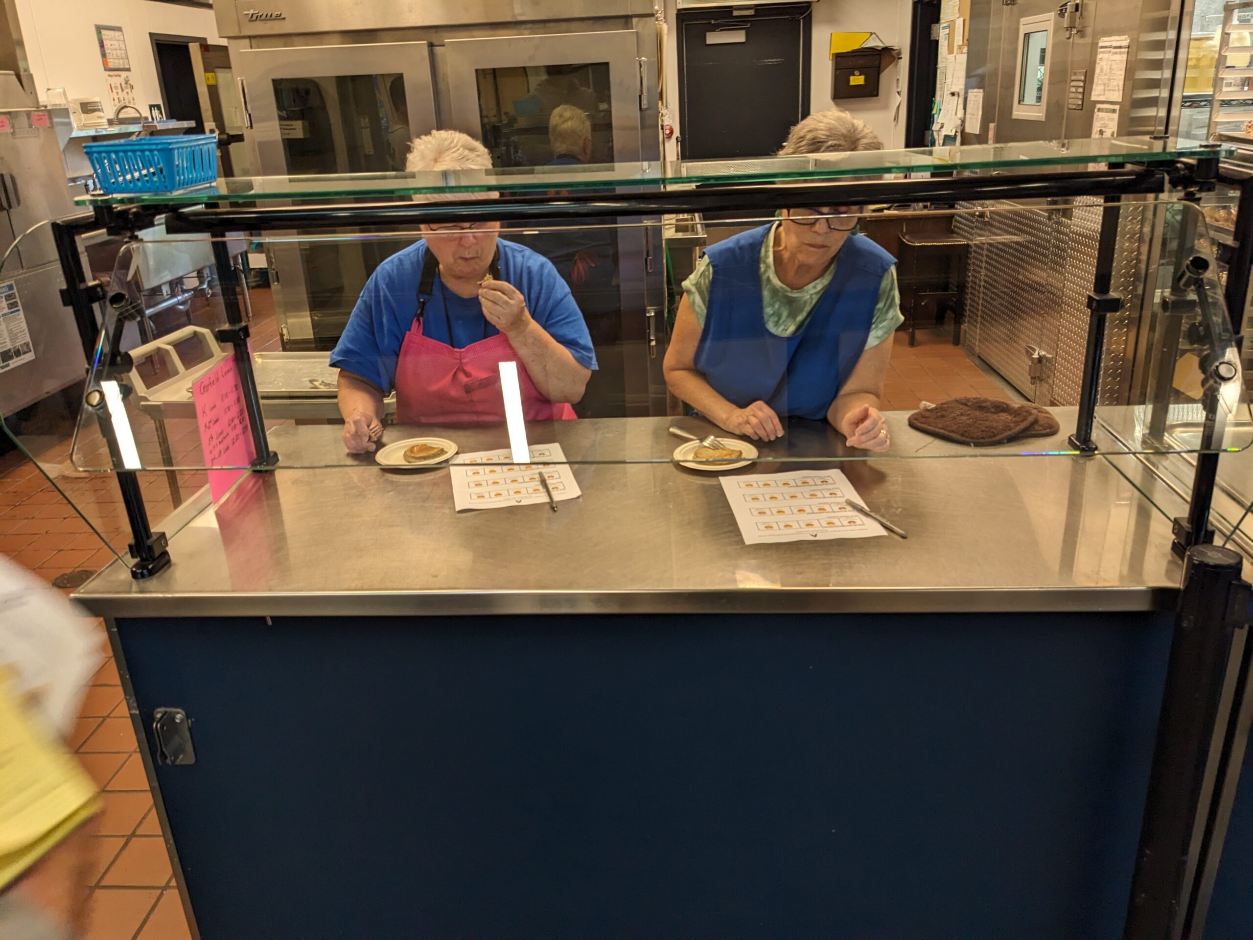 Two people taste testing buckwheat pancake mix in a cafeteria