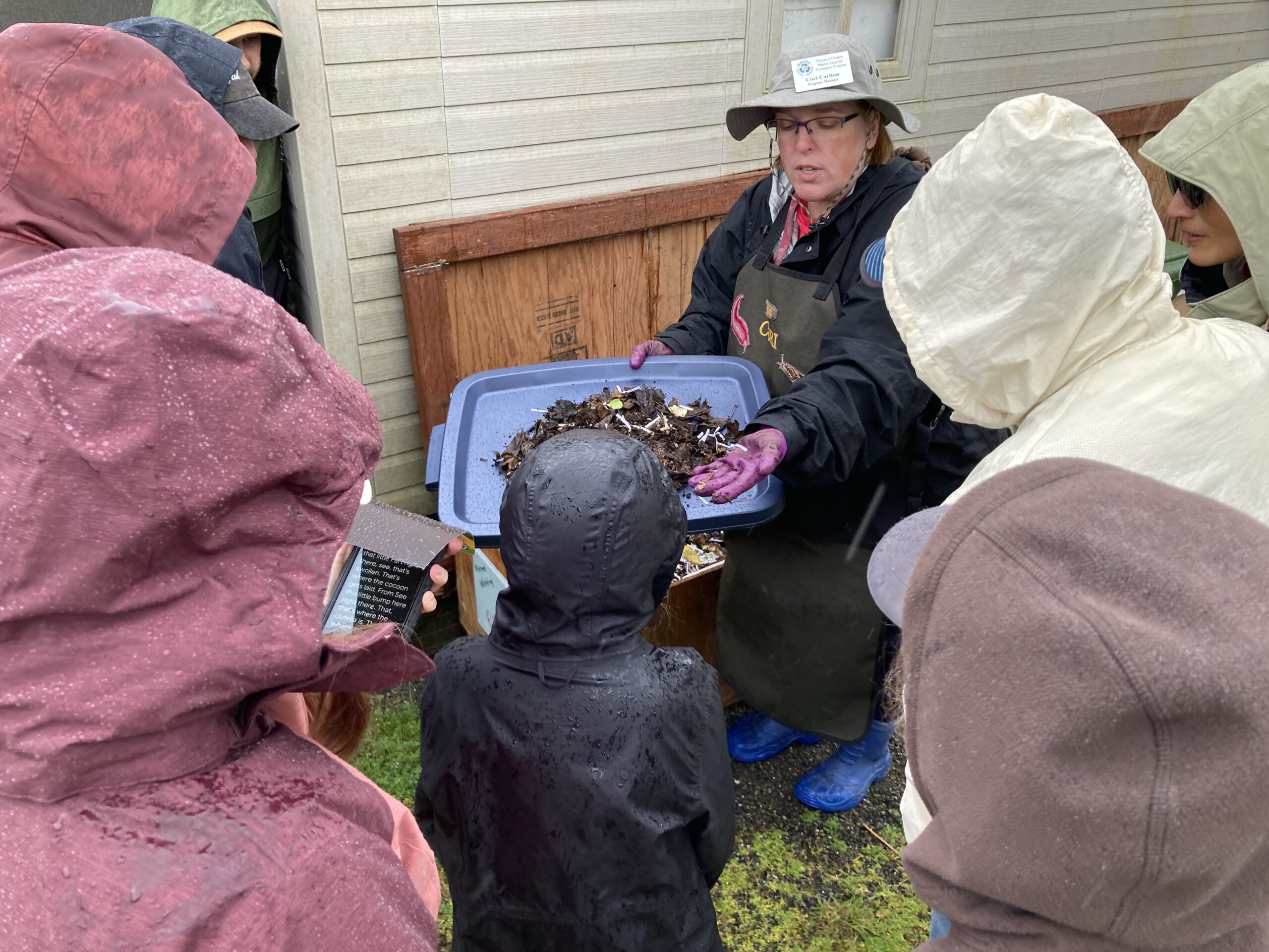 Thurston County Master Recycler Composter volunteer teaching workshop participants about worm composting in front of a worm bin.