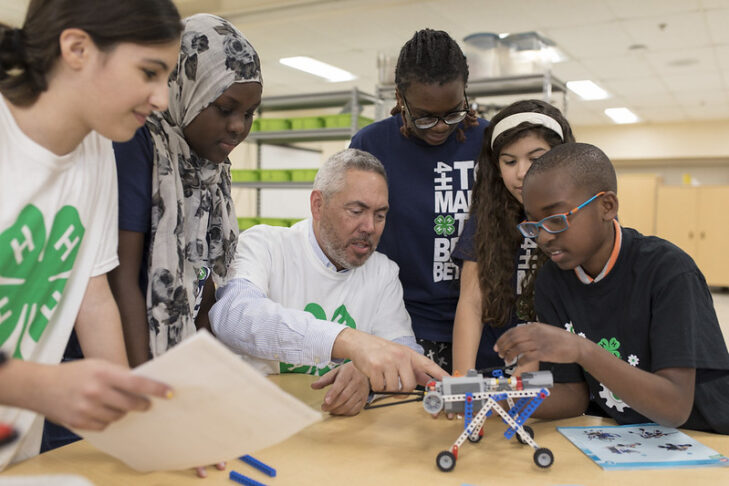 4-H youth and volunteer working on a robot project