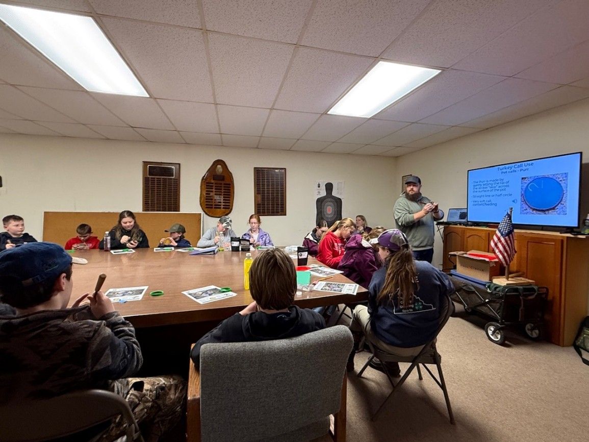 Justin Grimm from the NWTF teaching 4-H youth ho w to use their hand made turkey calls.