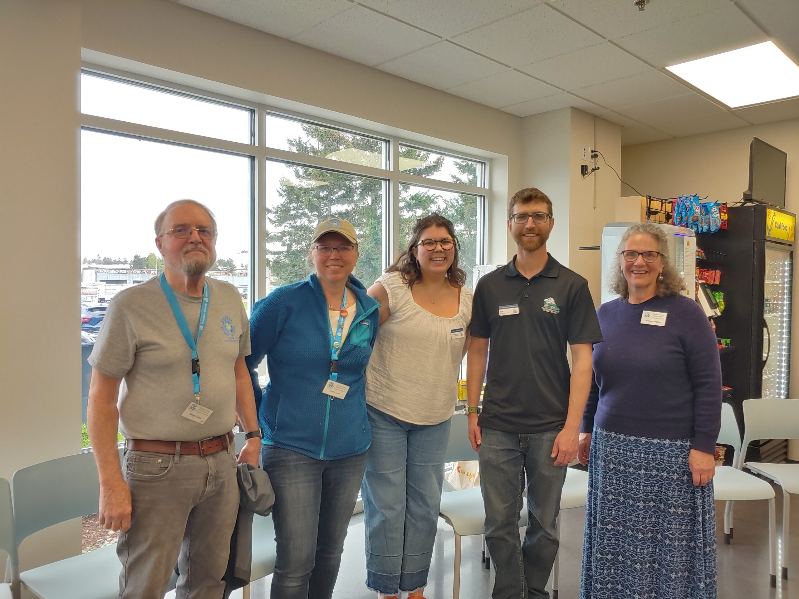 MRC volunteers and Thurston County Solid Waste staff posing for a photo in a room. 