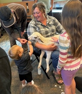 Petting a baby lamb at an IYRP event at the Chehalis Library