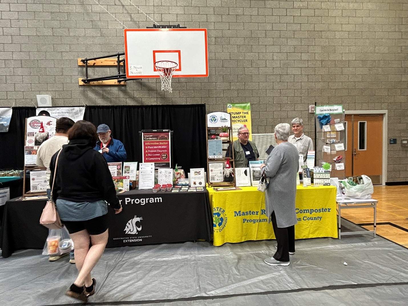 Volunteers sharing gardening and waste reduction information at a community event