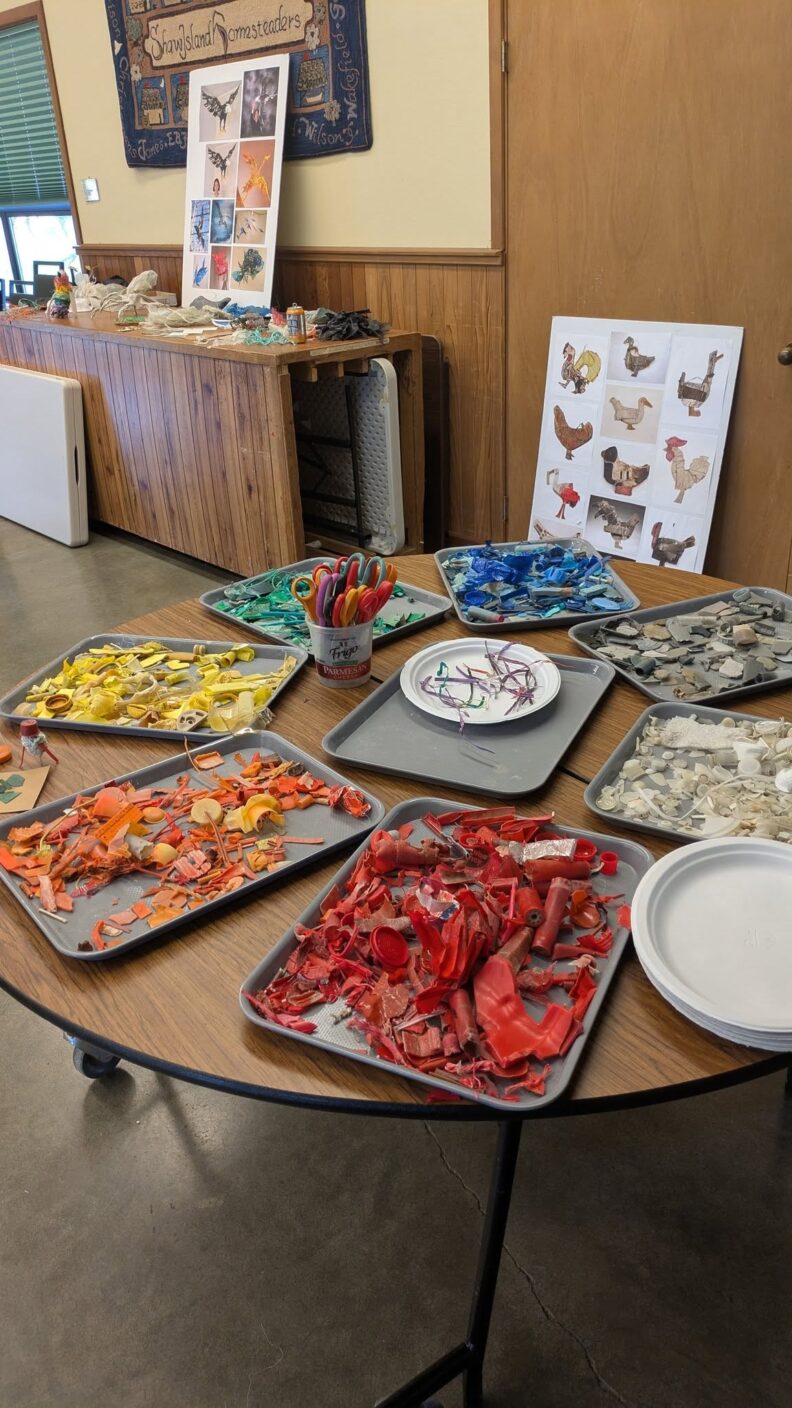 Colorful plastic pieces, sorted by color and arranged around a table on trays
