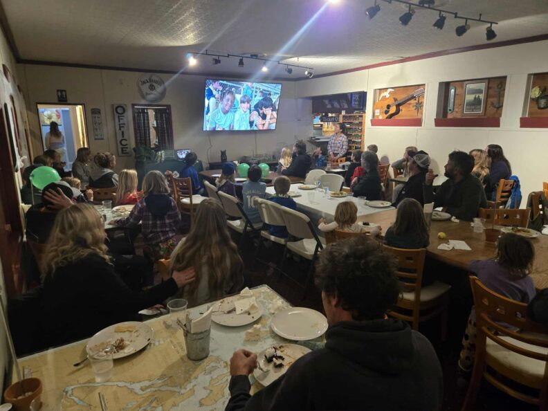 Orcas Fur & Feather 4-H Club members and their families watch a slideshow of the past 4-H year during their annual awards banquet!