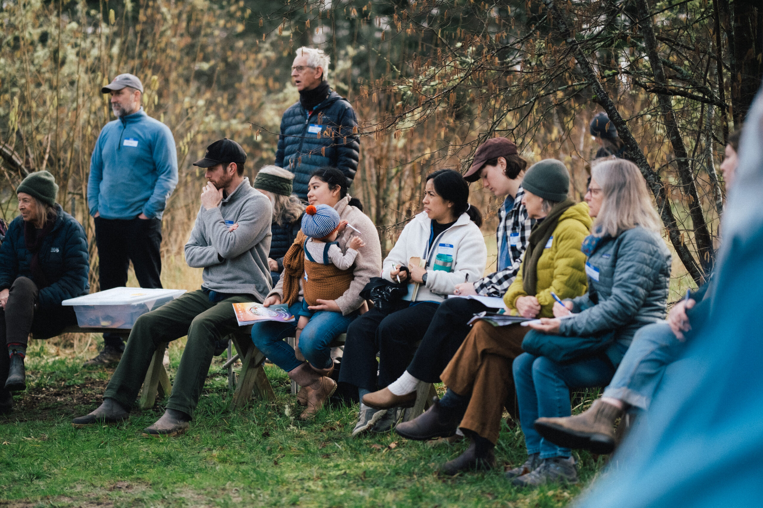 Group of people sitting outdoors taking notes