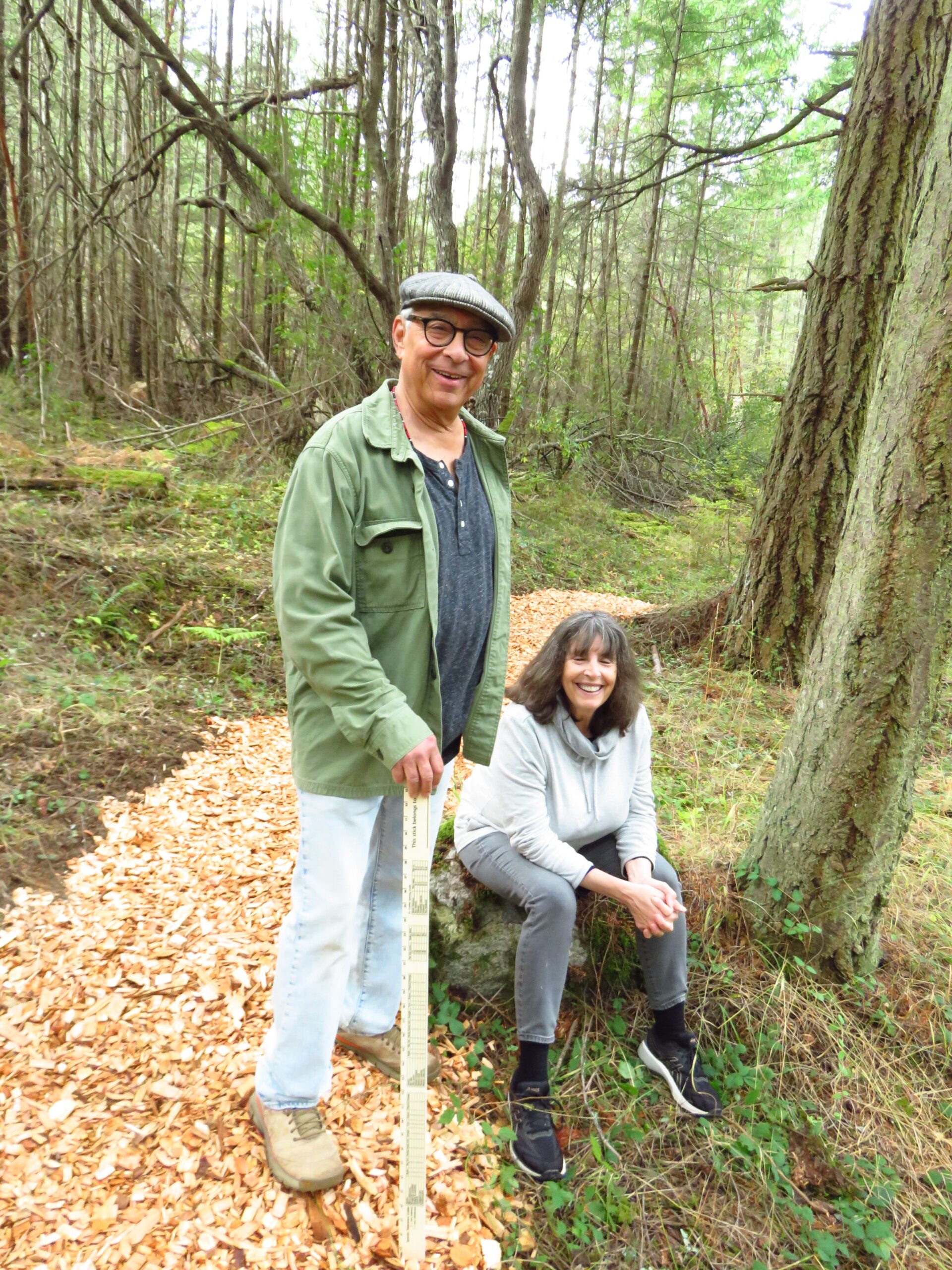 A man standing next to a woman sitting on a stump