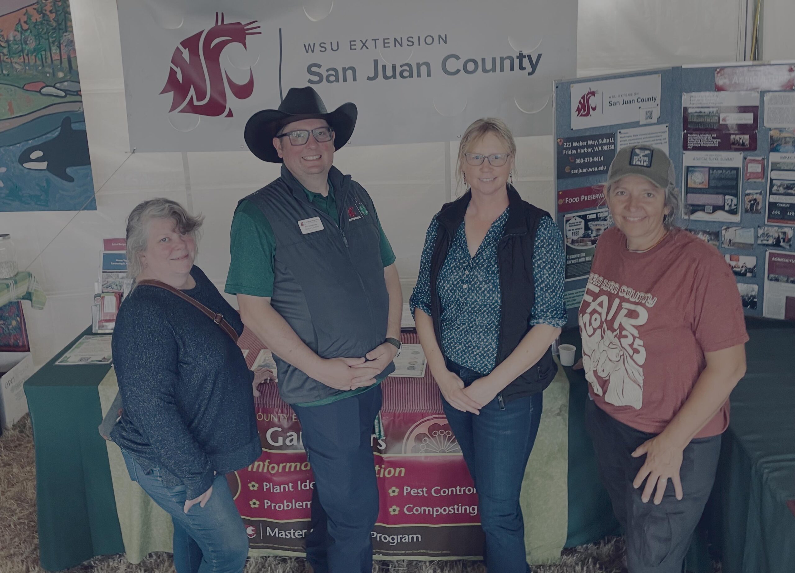 Group of Extension staff standing in front of outreach table