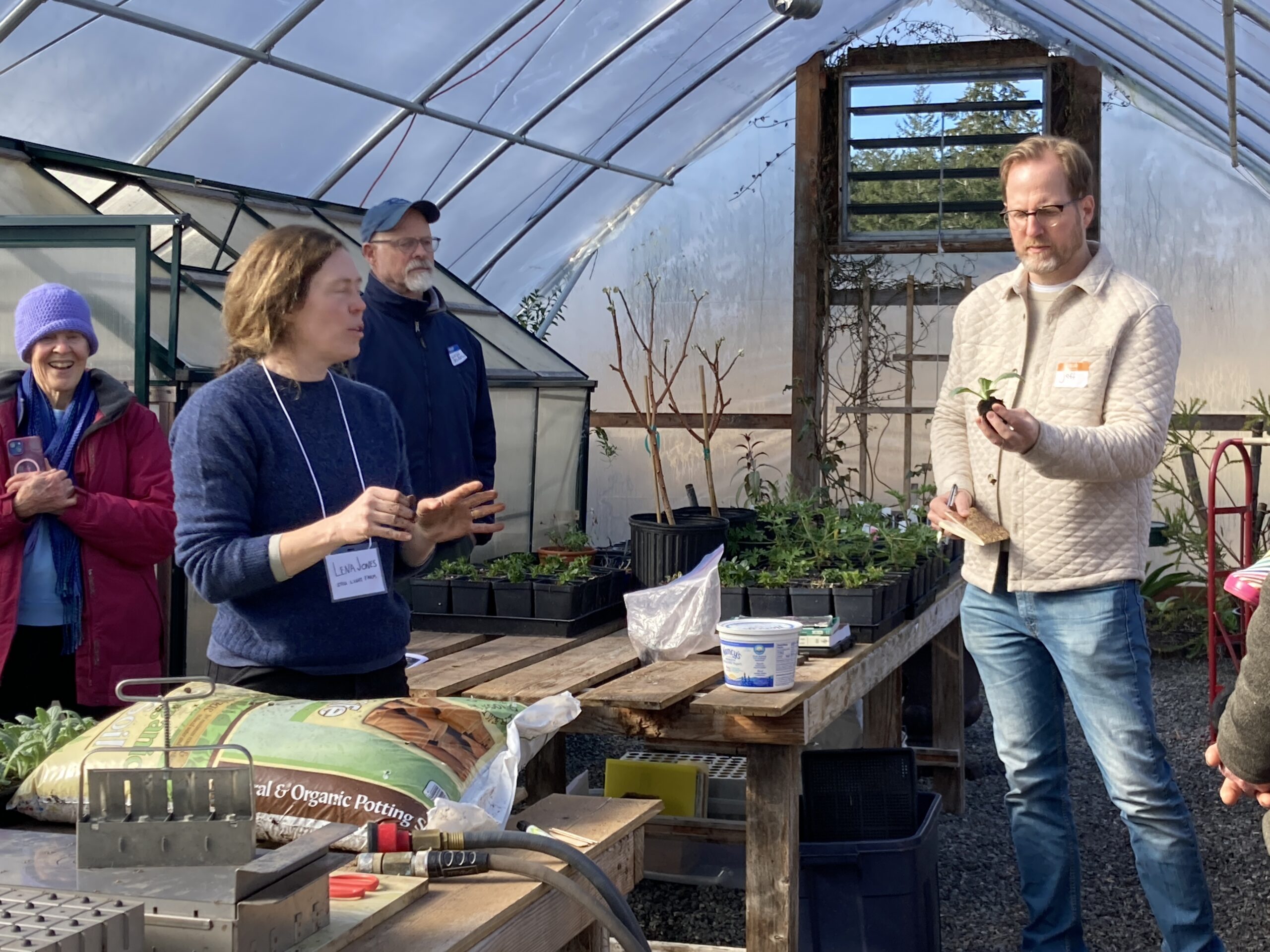 Group of people in greenhouse looking at plants