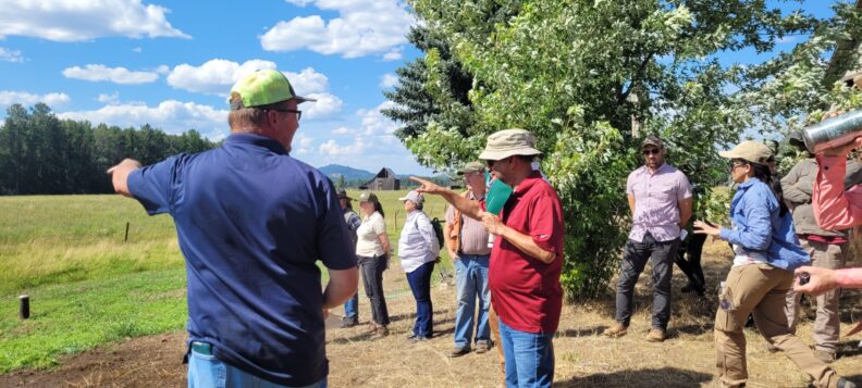 Group of people at a farm talking. 