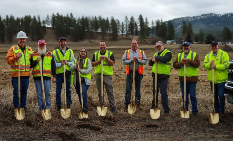 Picture of 9 people wearing safety vests, standing in a field, and each holding a gold shovel.  Project leaders from key stakeholder groups gathered for the groundbreaking ceremony of a Stevens County broadband project years in the making. 
From left: Steve Schulte, NoaNet-Project Manager; Brent Smith, NoaNet-OSP Engineer; Nick Ulrich, NoaNet-Deployment Manager; Bert Klimas, Stevens 
County Broadband Action Team (BAT); Justin Defries, NeuBeam; Jim Cooper, Paramount-General Foreman; Frank Metlow, Tri-County Economic Development 
District-Deputy Executive Director; Greg Young-Stevens County Commissioner; and Mike Stotts, Northwest Line Builders-Foreman.  Photo courtesy of TEDD.