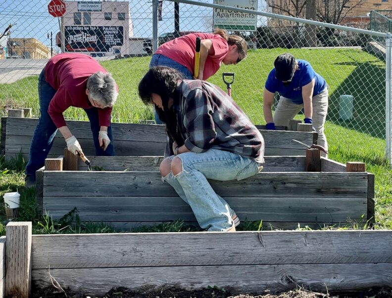 4 Master Gardeners working in a raised bed garden