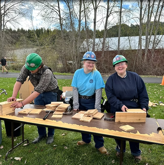 3 participants at Ferry County Conservation Fair building birdhouses on a table