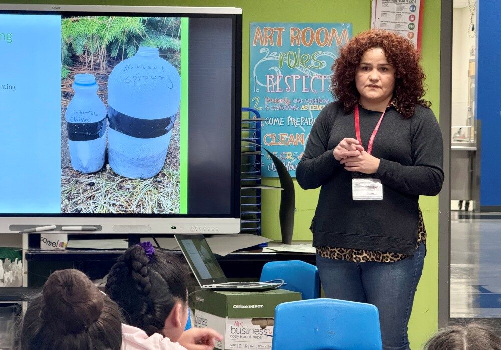 Master Gardener intern Carmen teaching kids at 9 Mile Falls Elementary School how to make Milk Jug greenhouses.