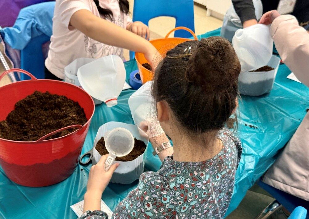 Kids at 9 Mile Falls Elementary School making Milk Jug greenhouses at the class taught by Master Gardener intern Carmen.