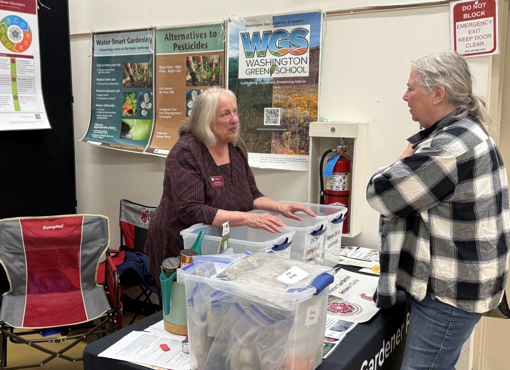 Master Gardener Jackie conversing with a customer at the Colville Home & Garden Show booth.