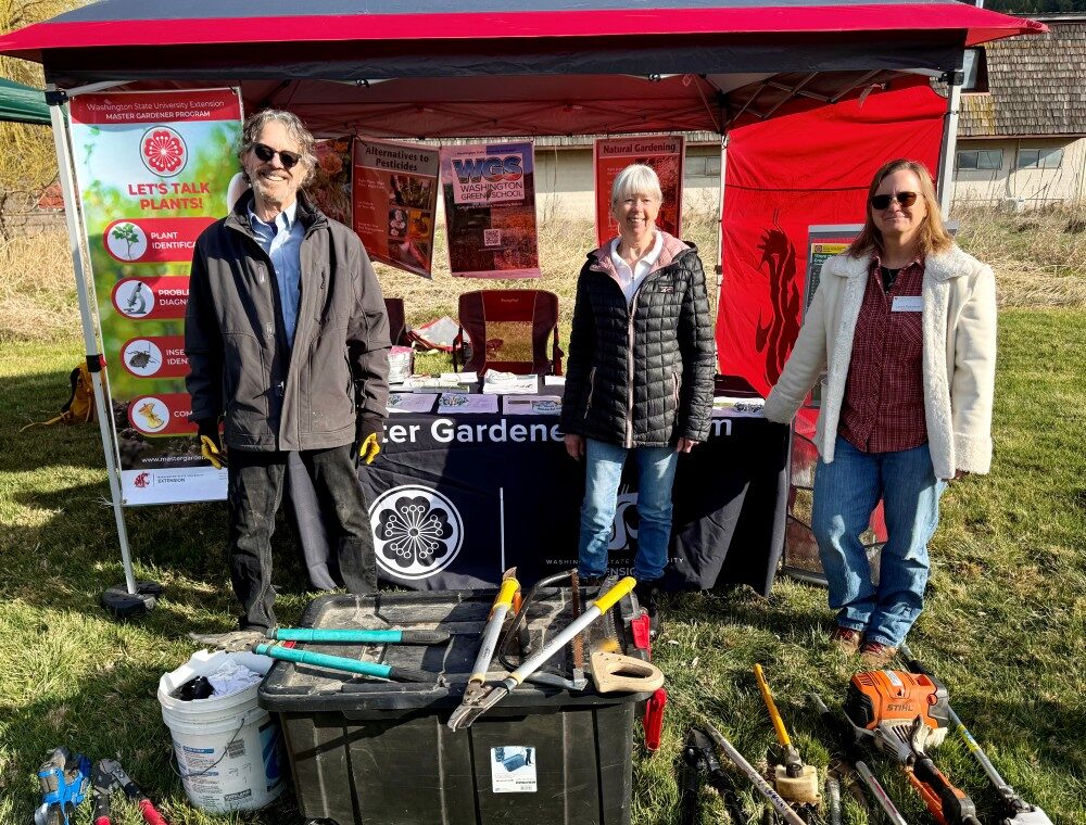 Master Gardener Phil (left) and Laura (right) with MG Intern Linda (middle) working the booth and pruning display at the Conservation District Tree Sale event.