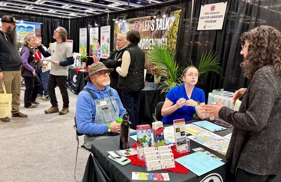 Stevens County was represented at the state Master Gardener booth at the NW Flower & Garden Show in Seattle. Master Gardener Phil (standing) and Christine (seated) converse with attendees.