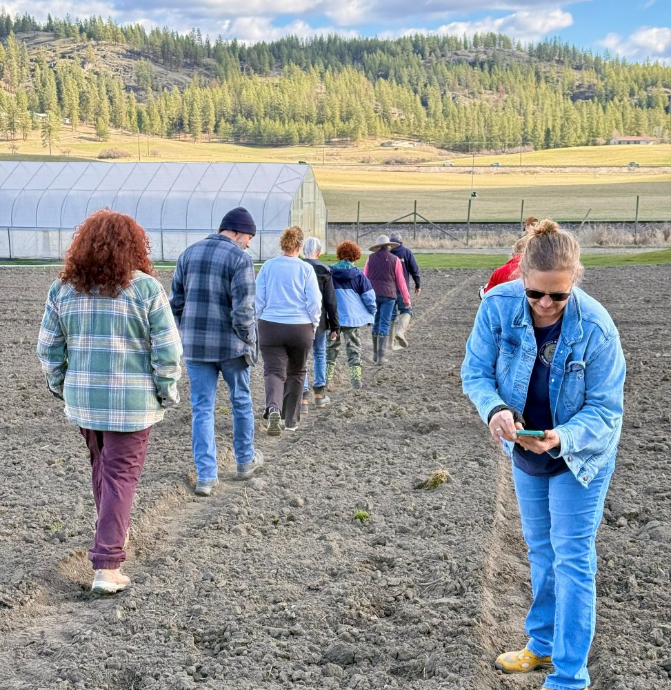Last in-person training for the 2025-2026 Master Gardener class was a field trip to Front Porch Farm where they learned about growing vegetables. Students walk in single file to see one of the larger greenhouses up close.