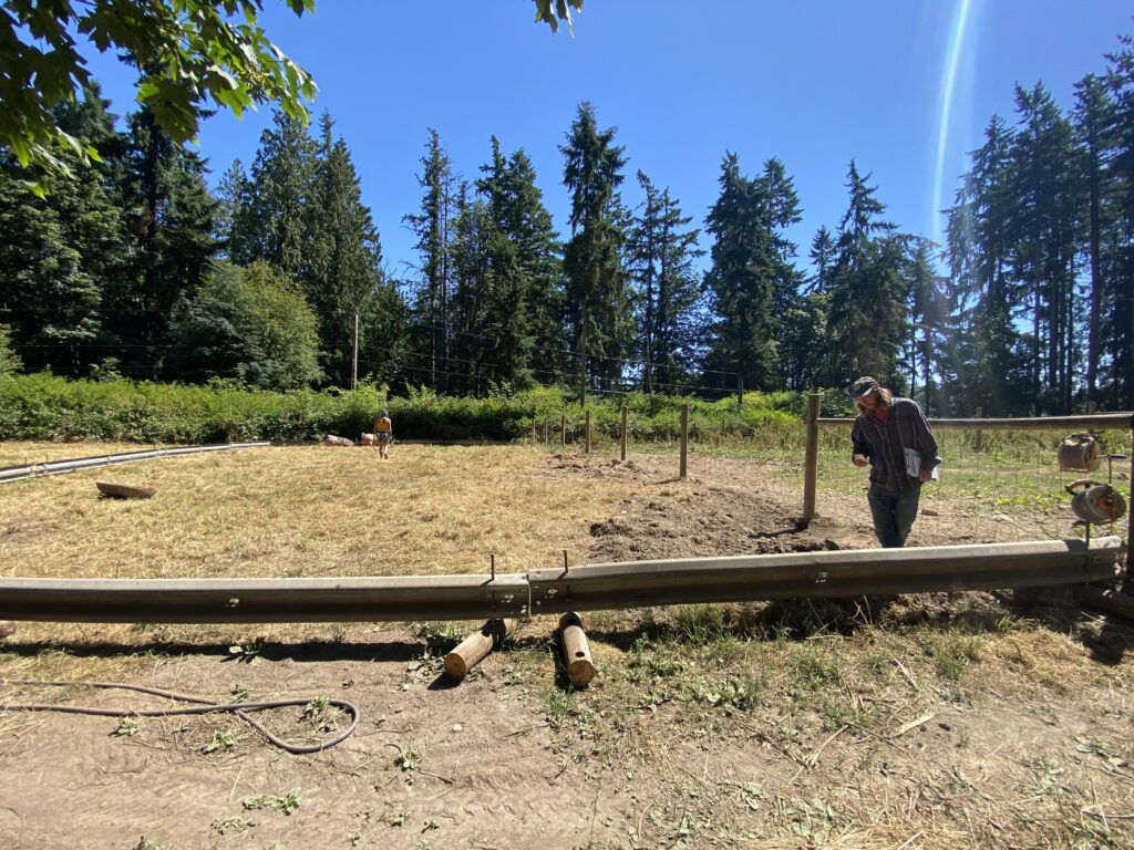 A picture of the fencing Brian made, showing two guardrails affixed to log rounds with shot steel piping 