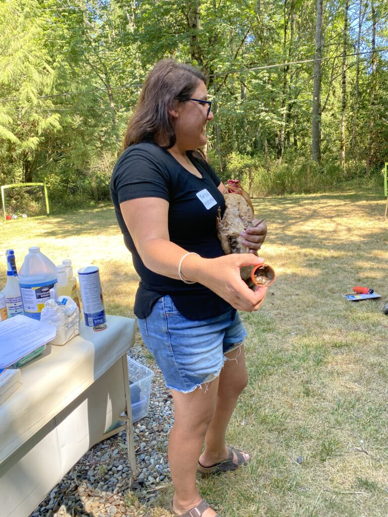 Karissa holds an orange hen as she speaks about chicken first-aid