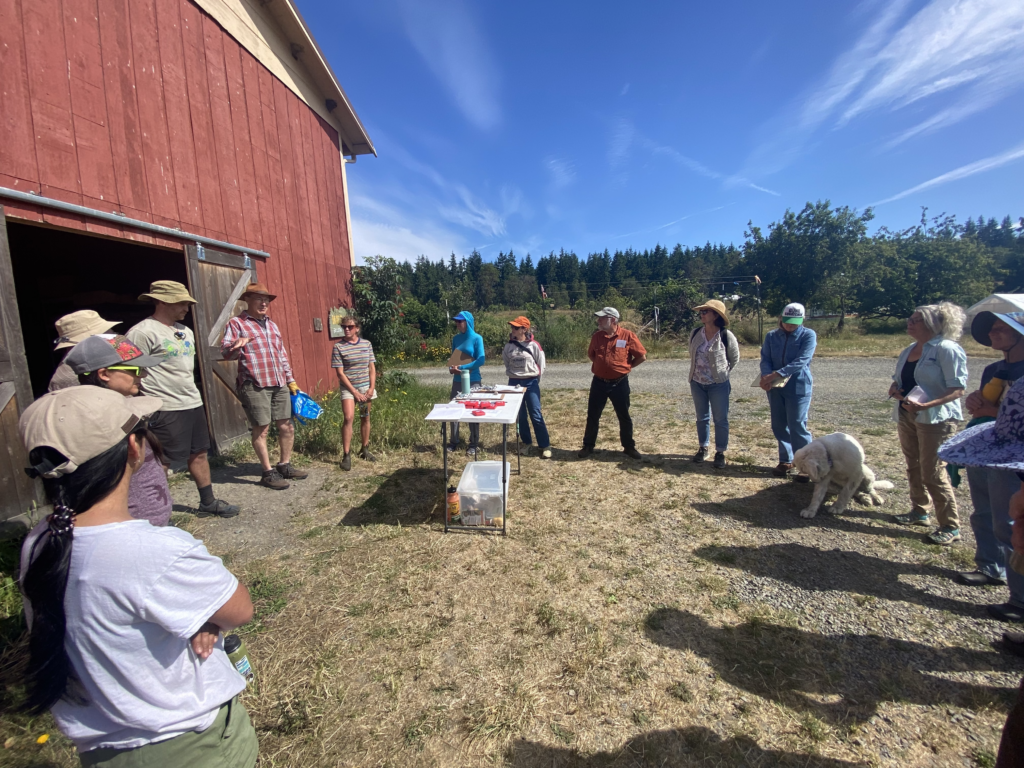 Class participants gather in front of a red barn