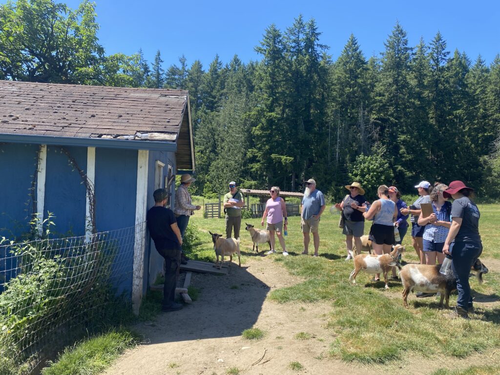 Participants stand outside milk parlor and discuss ruminant care