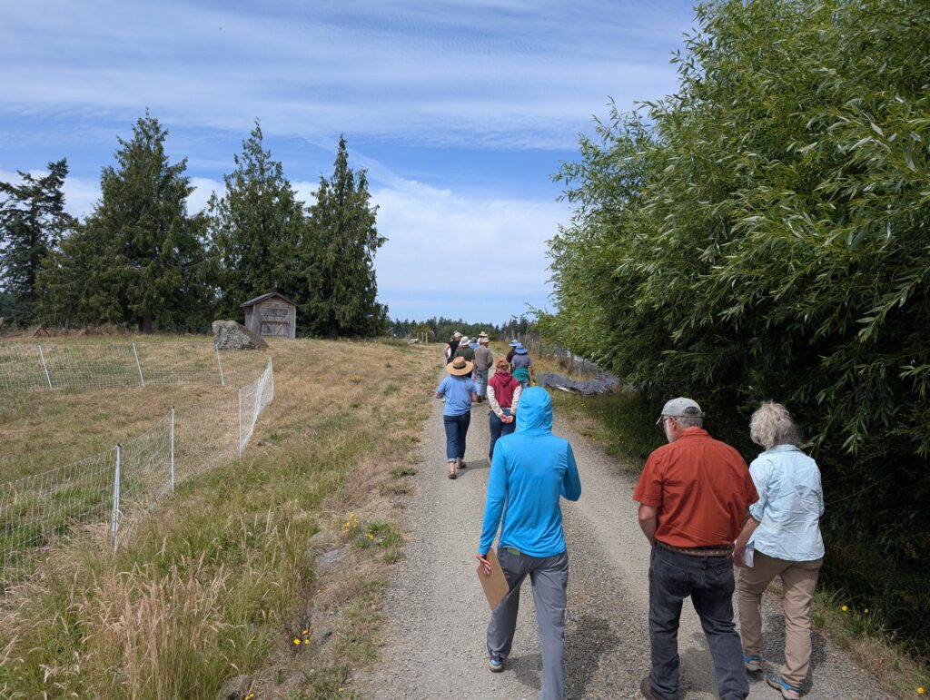 Class participants walk up a gravel road to the next field 