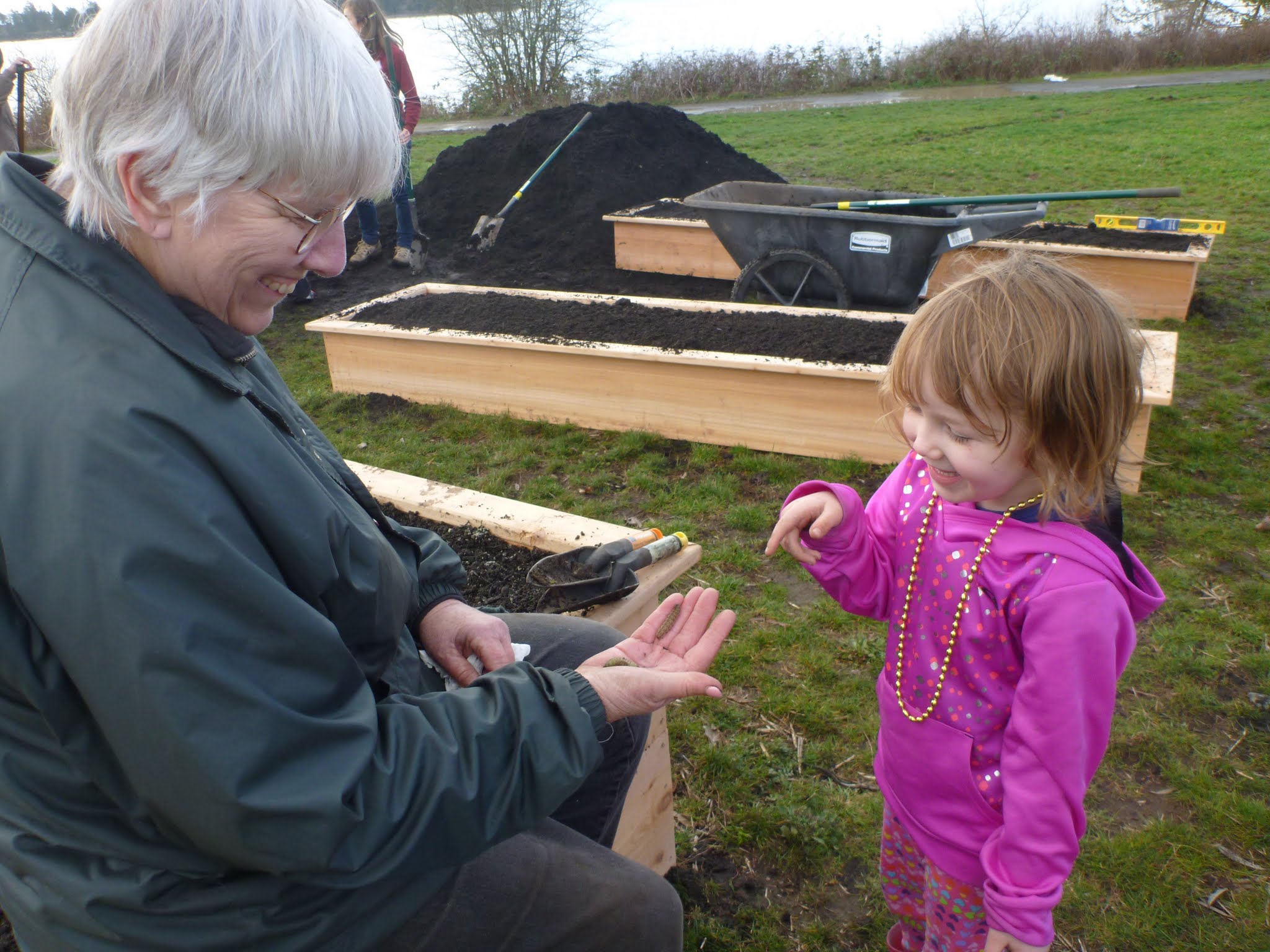 Sharon Collman is showing a child a caterpillar.