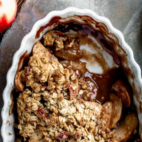 a partially eaten apple crisp in a casserole bowl
