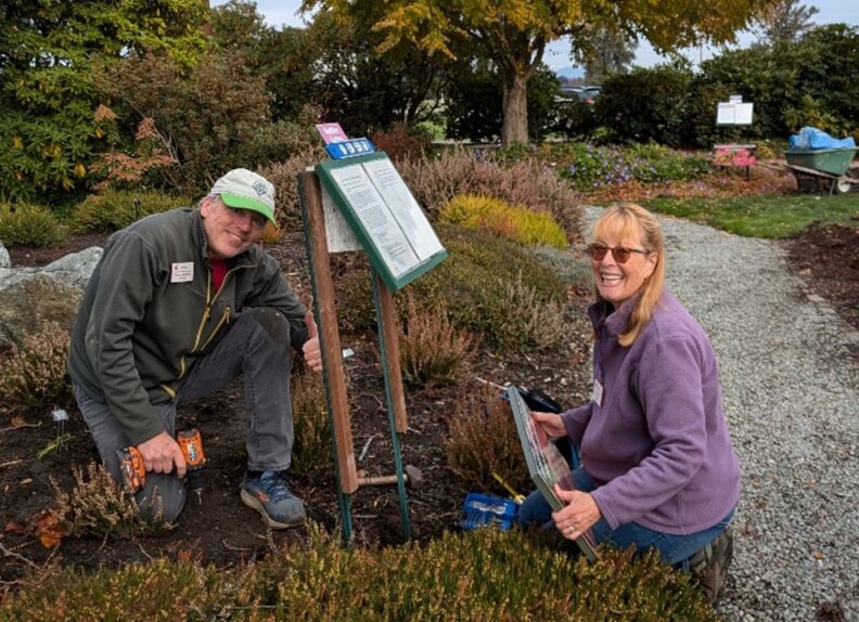 Master gardeners installing signs at the garden