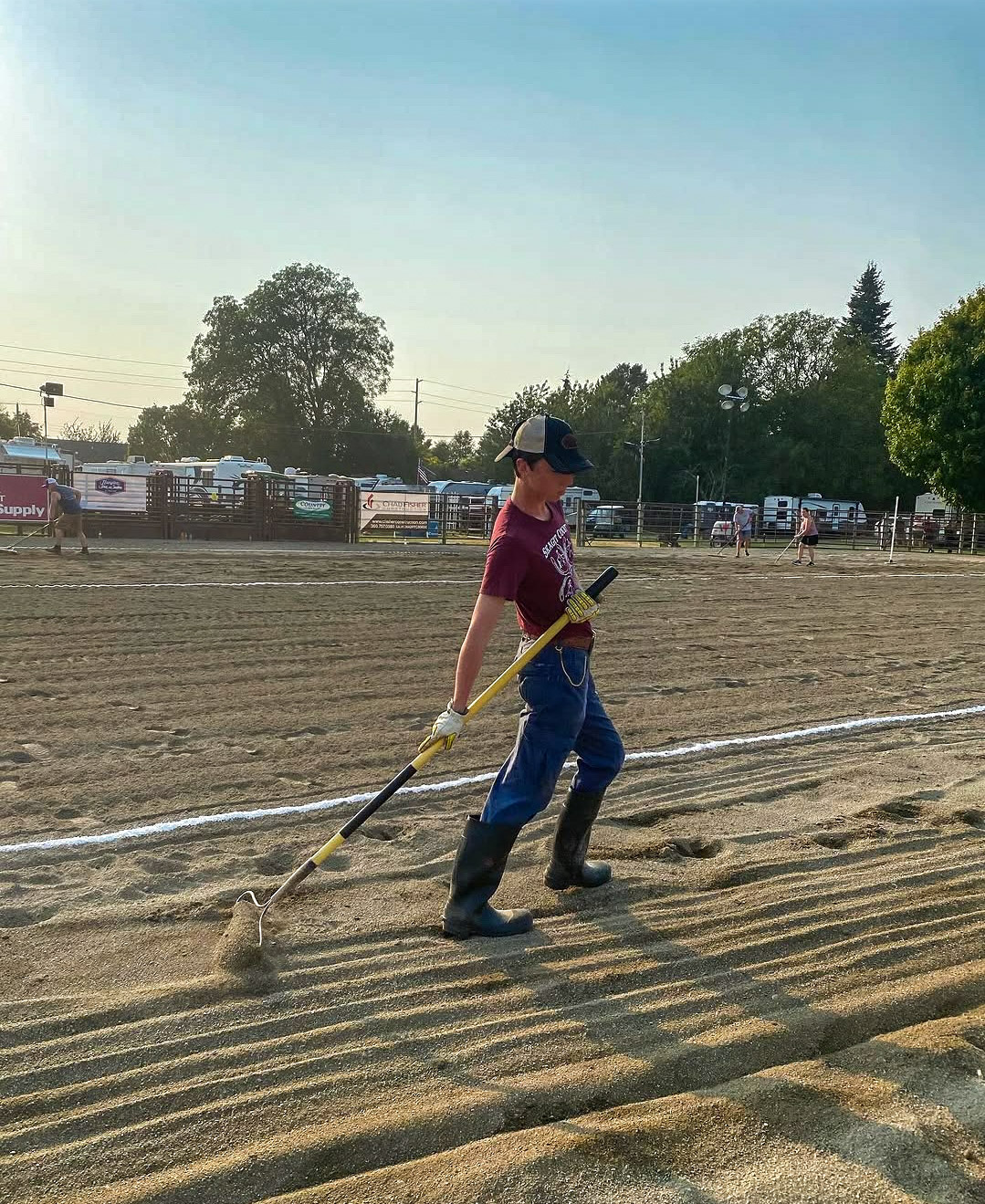 4-H member raking the horse arena