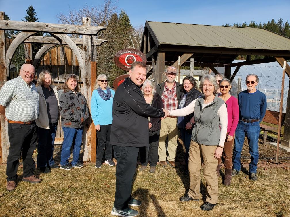people standing outside garden and shaking hands