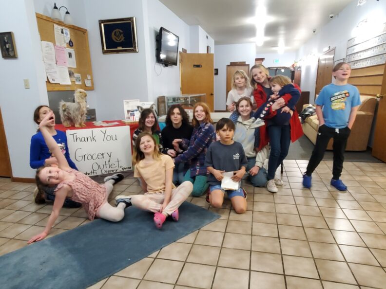 Members of the Happy Haystacks 4-H club with sign thanking sponsor Grocery Outlet