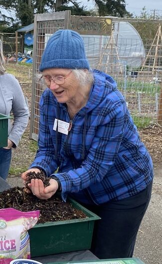 two women looking at a worm bin