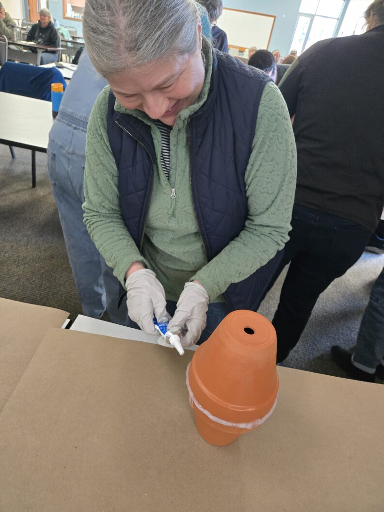 Class attendee participating in making an olla.