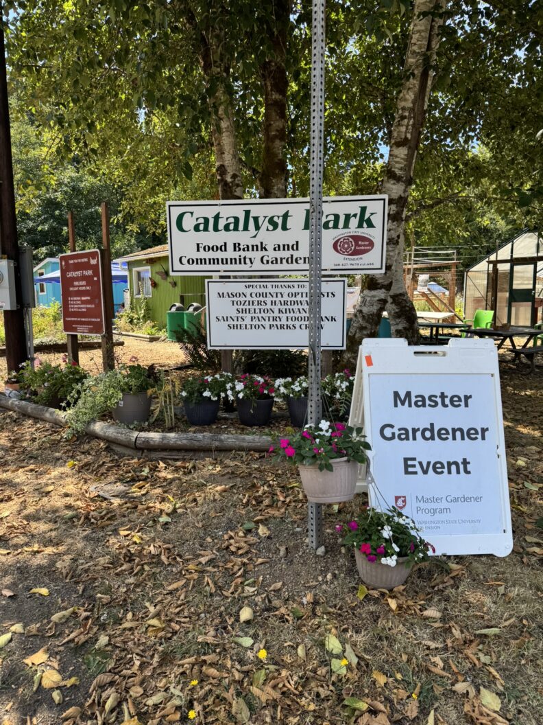Catalyst Park & Master Gardener event signs with flower decor.