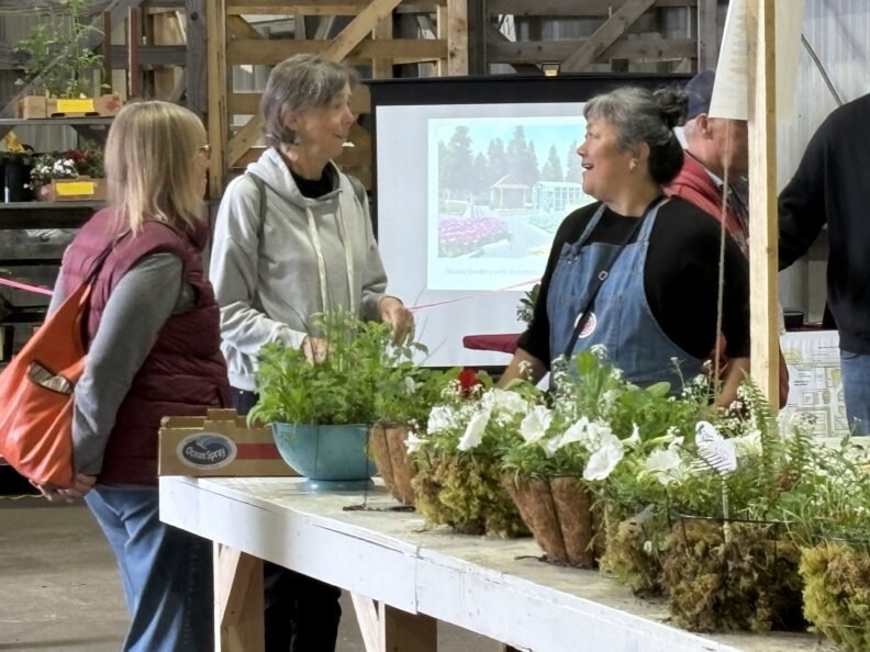 Master Gardener helping customers at the plant sale.